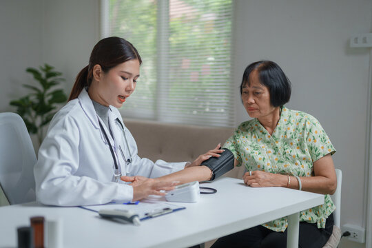 Doctor measuring senior woman's blood pressure during home visit