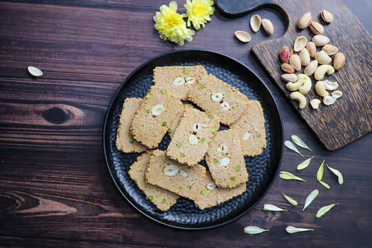 Til gajak, a traditional Indian winter sweet made with sesame seeds, jaggery, ghee, and dry fruits. Crunchy til chikki, a festive treat for Makar Sankranti. Tilgul. Sesame candy. Copy Space. Winter fo