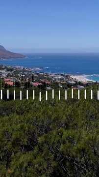 Animation of data processing over aerial view of landscape with trees, mountains, cityscape and sea