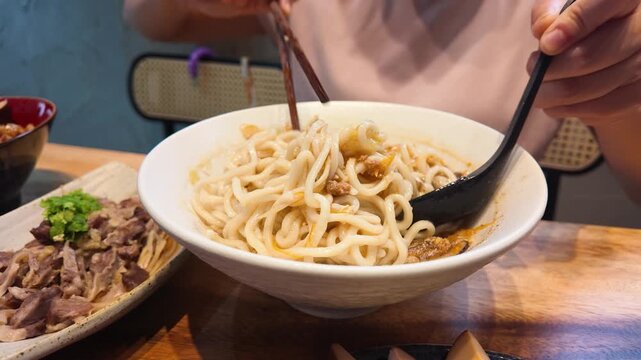 Person Mixing Spicy Hot and Sour Noodles with Minced Pork