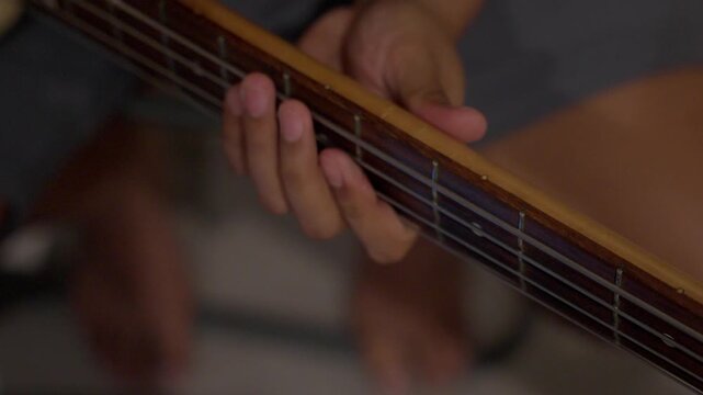 Cinematic Close up of Hand playing Electric Bass Strings During Practice Session