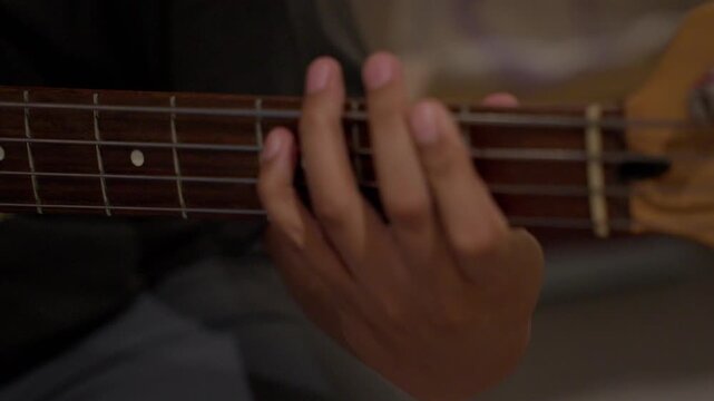 Cinematic Close up of Hand playing Electric Bass Strings During Practice Session