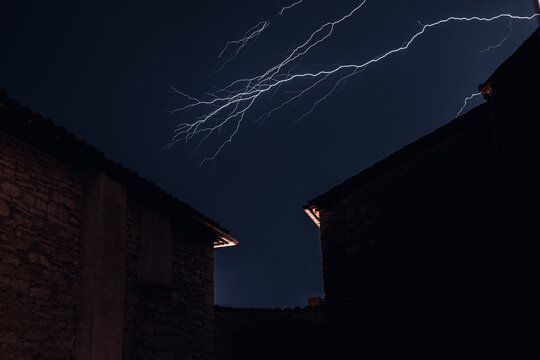 Multiple Branched Lightning Strike Over Ancient Stone Buildings Night Scene