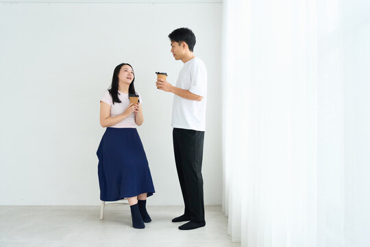 Young Japanese Man and Woman Talking Together in Relaxed Indoor Setting