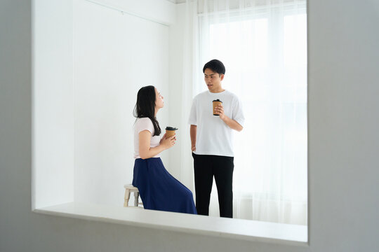 Young Japanese Man and Woman Talking Together in Relaxed Indoor Setting