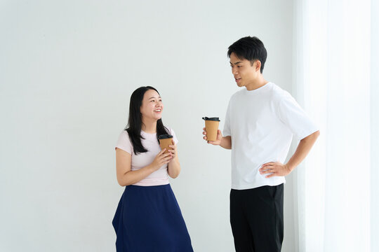 Young Japanese Man and Woman Talking Together in Relaxed Indoor Setting