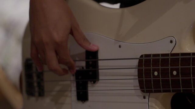 Cinematic Close up of Hand playing Electric Bass Strings During Practice Session