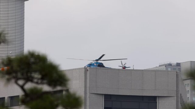 Blue Helicopter Landing on Rooftop Helipad in Tokyo