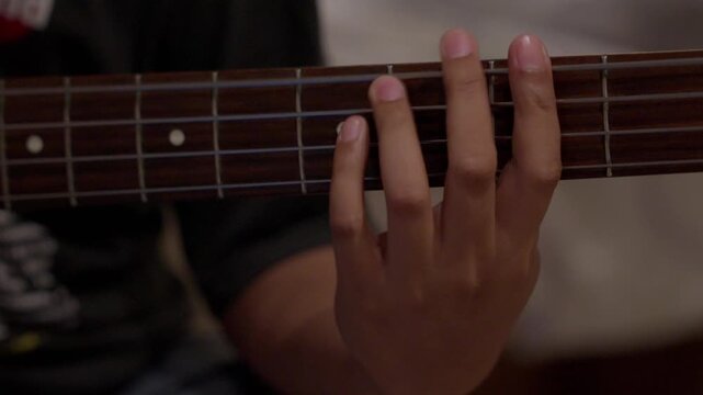 Cinematic Close up of Hand playing Electric Bass Strings During Practice Session