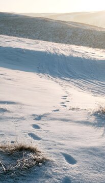 Serene winter landscape a peaceful snowscape with footprints leading to distant golden light