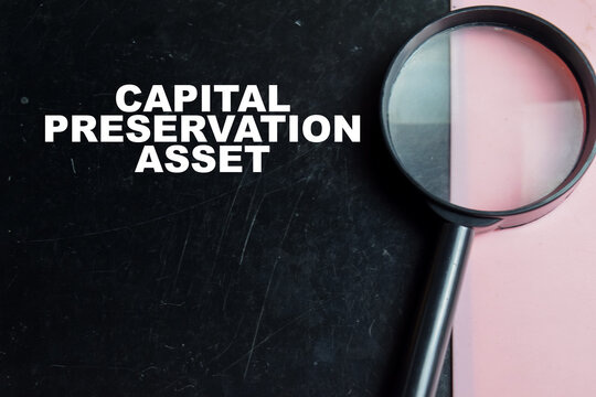 Concept of capital preservation asset write on color background with magnifying glass.