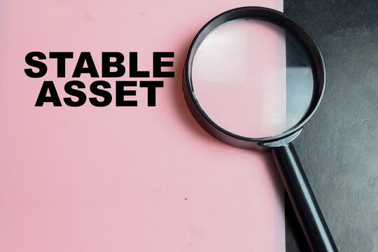 Concept of stable asset write on color background with magnifying glass.
