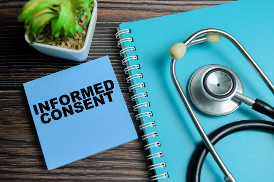 Concept of informed consent write on sticky notes with stethoscope isolated on Wooden Table.