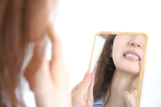 歯を確認する女性　歯並び、痛み
