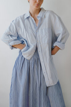Woman In Oversized Blue Button Down Linen Shirt Standing Hand On Hip