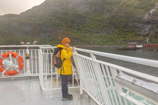 People, enjoying ferry ride between Bodo and Lofoten Moskenesoya summertime, child and adults on a ferry on sunset