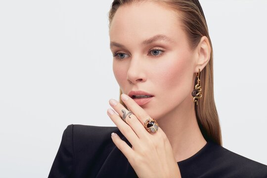 Close up portrait of a beautiful elegant woman with stylish jewelry on a white background. cute girl in black clothes. Beautiful girl with jewelry.