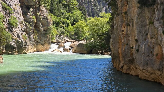 Wild fast flowing mountain river streaming through a narrow rocky canyon gorge