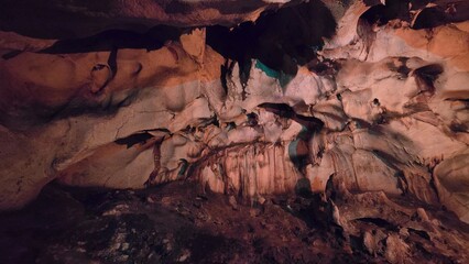 Stunning limestone formations inside an ancient cave illuminated with warm dim lighting © Asnyko