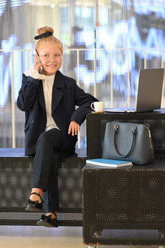 A little girl smiles during a phone conversation