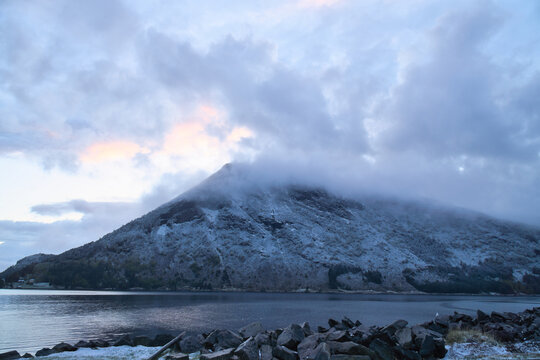 Snow-Covered Mountain in Fog by a Nordic Fjord