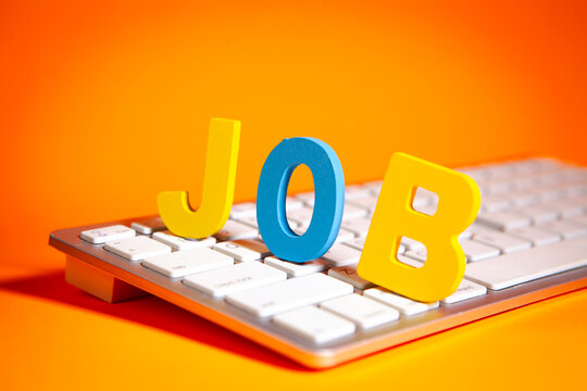 JOB spelled out with colorful letters on a computer keyboard, orange background