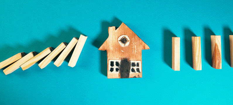 Wooden toy house and dominoes on a blue background.
