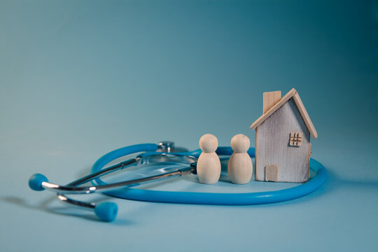Stethoscope and model of a house on a blue background. Health care concept.
