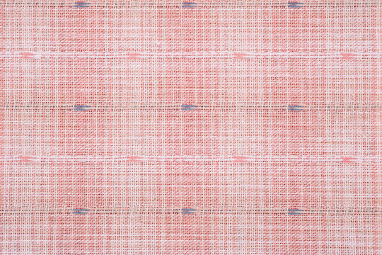 Close up of textured pink linen fabric with subtle blue and white accents