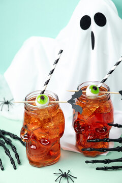 Spooky Halloween drinks in skull glasses with eyeball ice and ghost decoration
