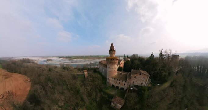 Stunning aerial 360 view of the ancient Rivalta Castle, showcasing its historical architecture amidst a picturesque European landscape with a river.