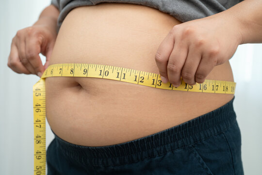 Asian woman with fat belly big size overweight and obesity with measure tape.