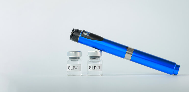 Blue injection pen resting on liquid vial bottle brings hopeful relief during daily medical therapy for weight management