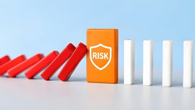 Orange domino block featuring a shield icon with the word 'RISK' stopping red falling dominoes, illustrating robust risk management and protective strategies.