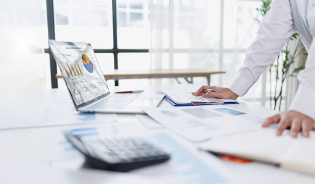 Business woman analysis summary graph reports of business operating expenses and work data about the company's financial statements.
