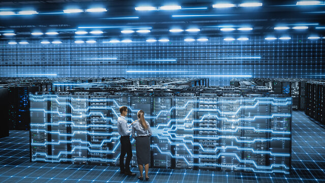 IT Specialist and Engineer Stand in data center, work, Activating Network Overlay Across Server Racks. Verify Connections, Monitor System During Cloud Infrastructure Cybersecurity Operations