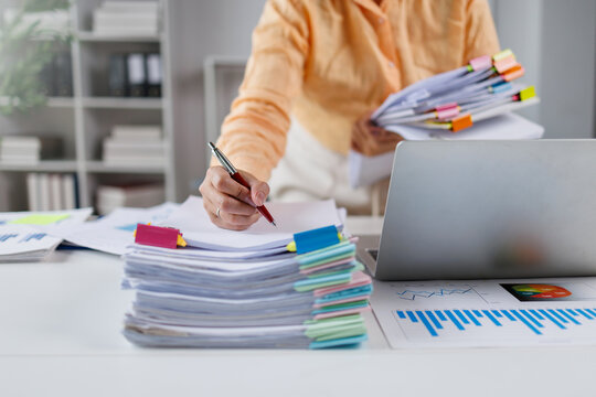 Businesswoman organizing financial documents and reports on office desk Financial Documents and Files in Office