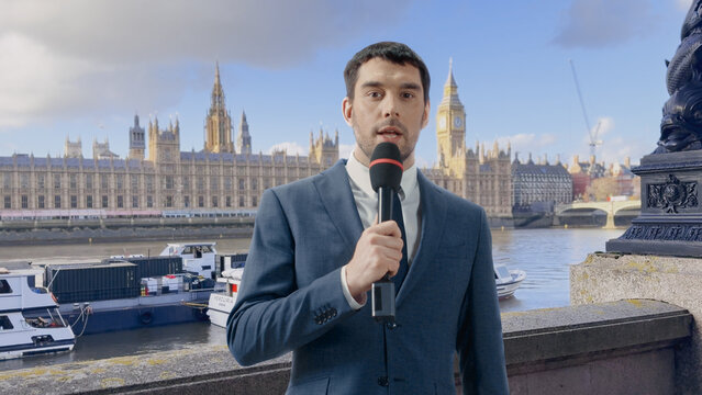 News Anchor Speaks Into a Handheld Microphone While Presenting a Live Television Report on Location by the River Thames, With the Houses of Parliament and Big Ben in the Background