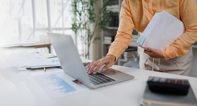 Document management. Businesswoman working with stack of paper files for searching and checking corporate files, document achieves on folders paper on office 