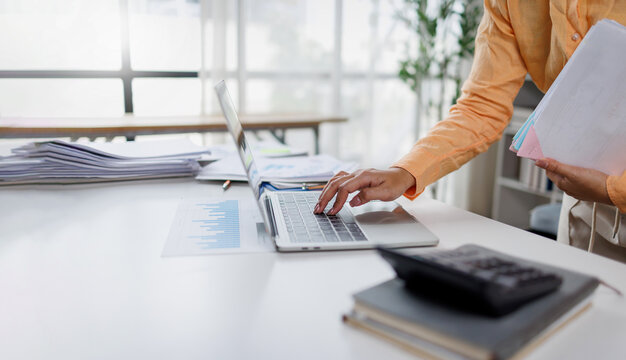 Document management. Businesswoman working with stack of paper files for searching and checking corporate files, document achieves on folders paper on office 