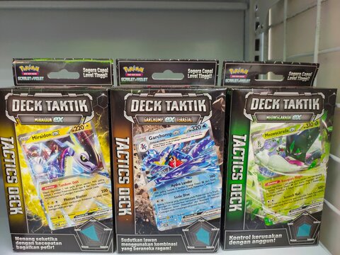 Malang, Indonesia - July 24, 2026: Three Indonesian Pok&eacute;mon Scarlet and Violet "Deck Taktik" boxes displaying Miraidon ex, Garchomp ex Terastal, and Meowscarada ex cards. 