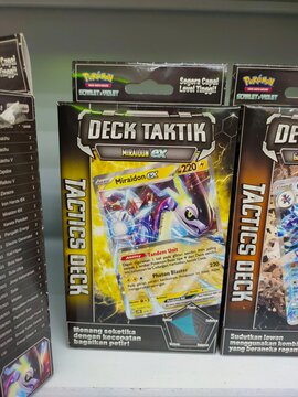 Malang, Indonesia - July 24, 2026: Indonesian Pok&eacute;mon Scarlet and Violet "Deck Taktik" box displaying Miraidon ex cards. 