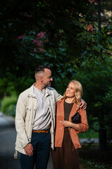 Fototapeta premium Couple walking and smiling enjoying a romantic park date