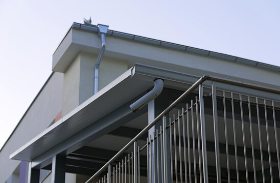 Building exterior with roof gutter and metal balcony railing