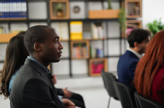 Multiracial business people sitting inside conference room for a seminar - Workshop, diverse entrepreneurs and meeting concept