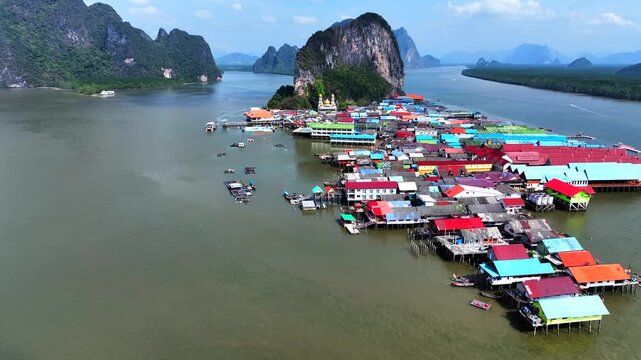 Aerial view of the floating village of Koh Panyi with colorful stilt houses and boats on the water in Ko Panyi, Phang Nga, Thailand.