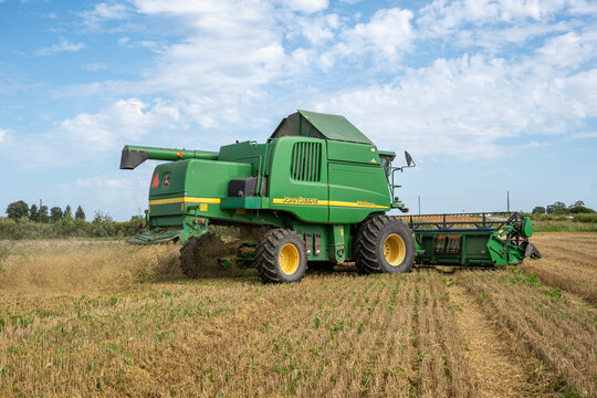 VECATE, LATVIA &ndash; AUGUST 10, 2026: A John Deere 9640 WTS combine harvester works across a harvested cereal field, spreading chopped straw and chaff during the summer grain harvest.