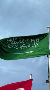 Saudi Arabia Flag Waving on Flagpole Against Clear Blue Sky