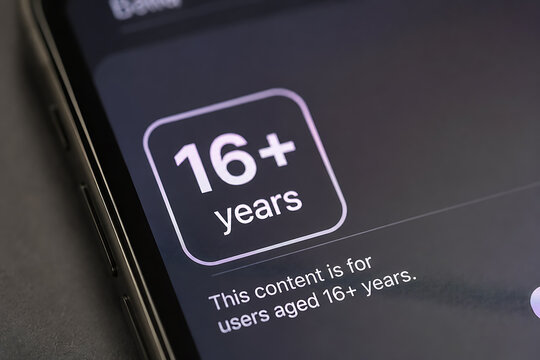 Close up of 16+ years label on smartphone screen as social media age restriction concept