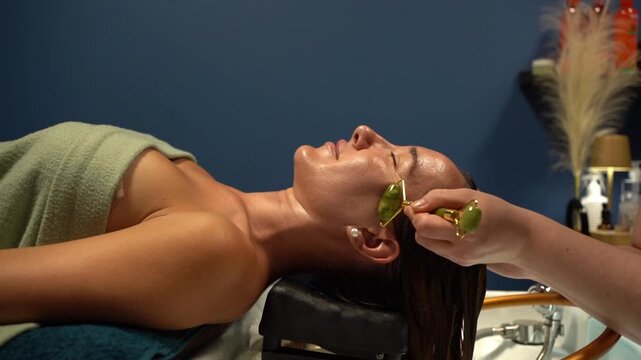 Relaxing facial massage with green jade roller